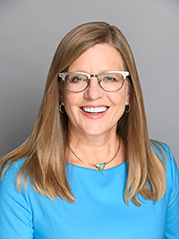 Mary Gutierrez, adult woman with long blond hair wearing eyeglasses and a blue shirt
